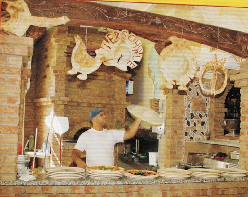 Pizzabäcker am Steinofen auf einer Abbildung im Eierschale-Flyer von 2008