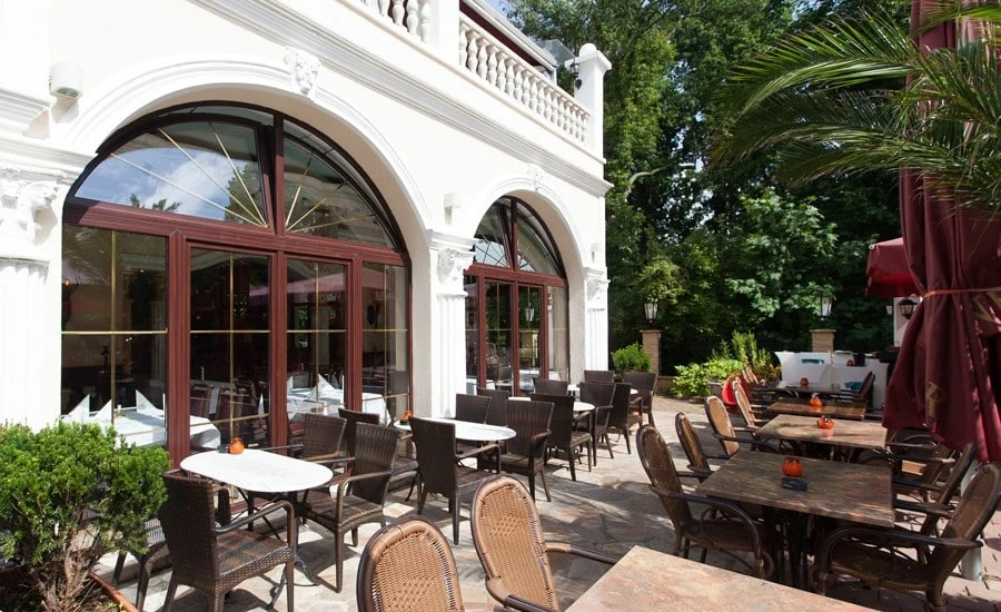 Sonnige Terrasse der Eierschale mit Tischen und Palmen